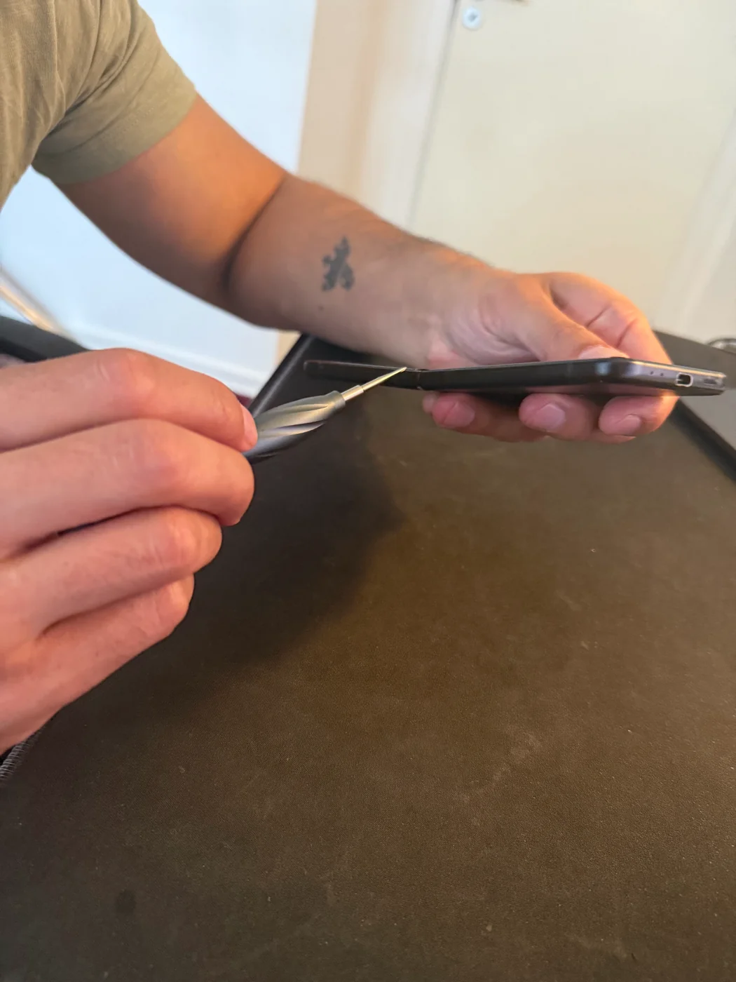 Reza åbner en telefon med specialværktøj under en reparation